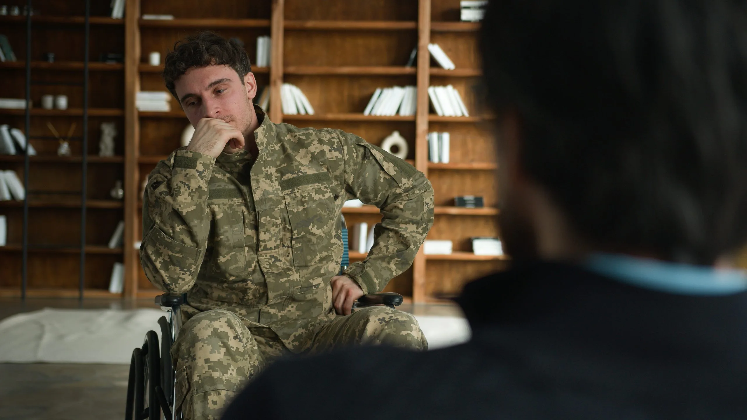 Military service member in wheelchair in therapy session with healthcare provider