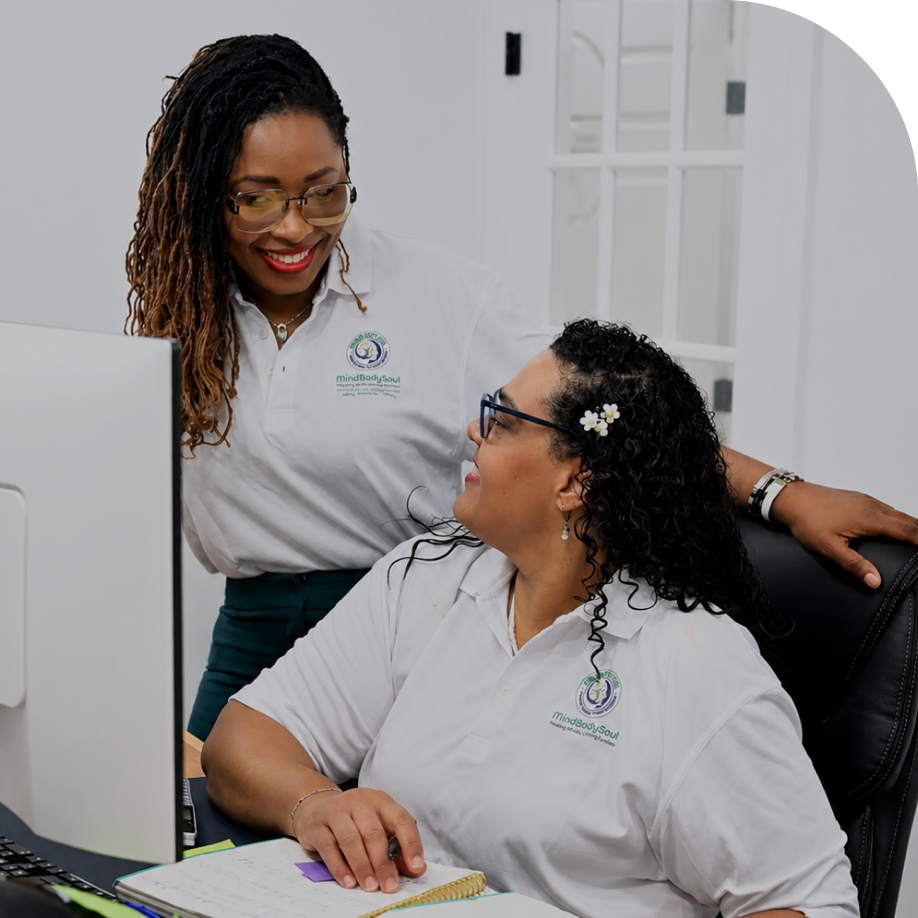 Mental health provider speaking with a patient seated at a desk in a clinical office setting
