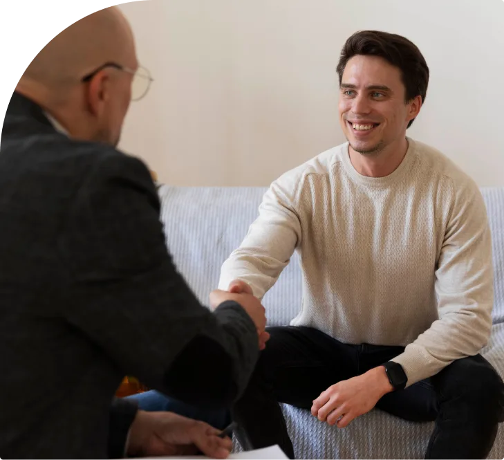 Psychiatrist shaking hands with a smiling patient during a psychiatric evaluation