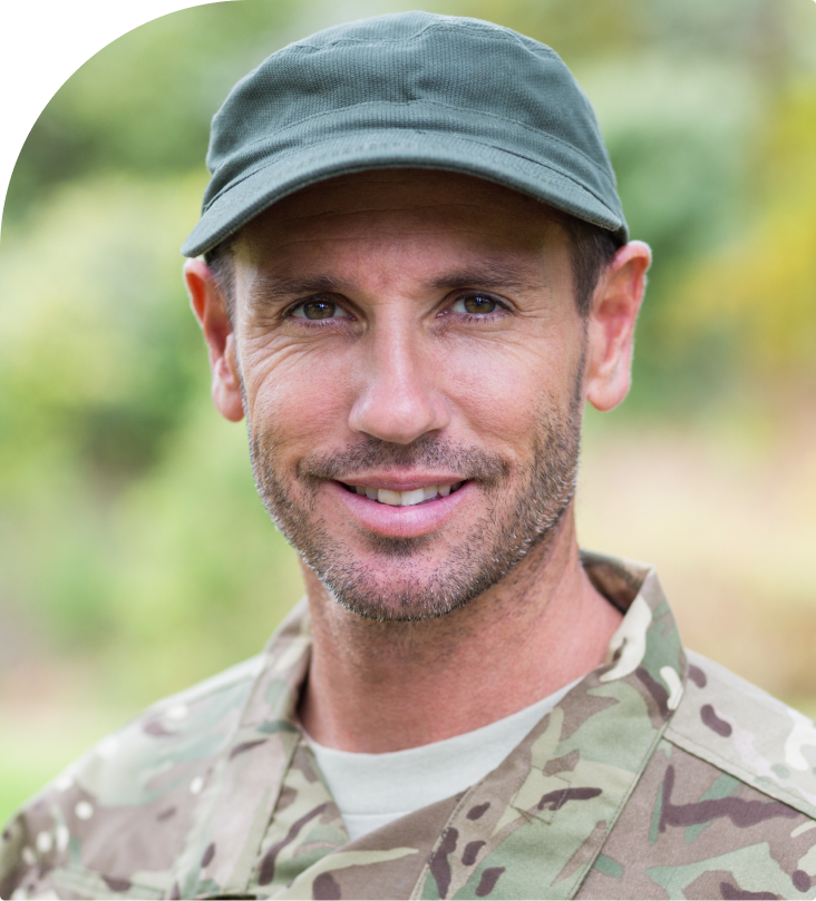 Male veteran in military camouflage uniform and cap outdoors