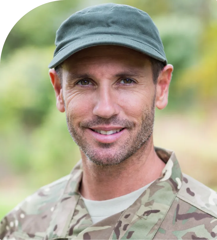 Male veteran in military camouflage uniform and cap outdoors