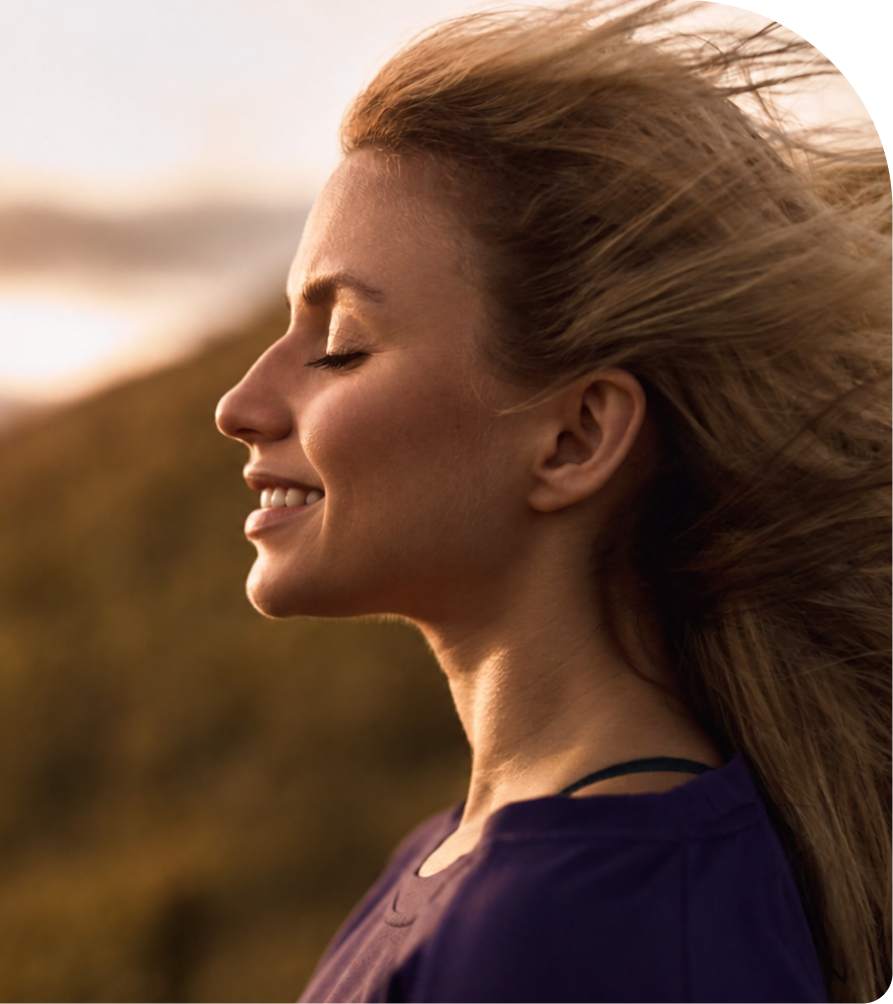 Woman with long hair smiling outdoors in natural sunlight