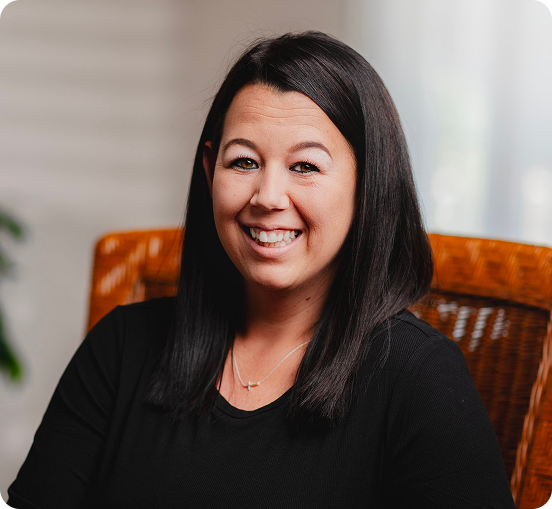 Brittany Craig, smiling at camera while seated in office chair