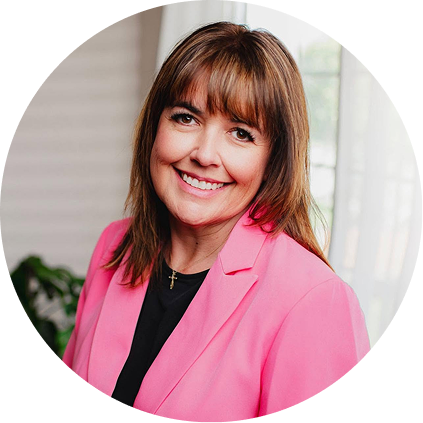 Woman smiling at camera wearing bright pink blazer in circular headshot