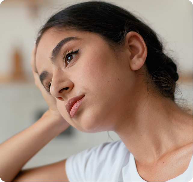 Woman touching her jaw in profile, suggesting facial discomfort or pain
