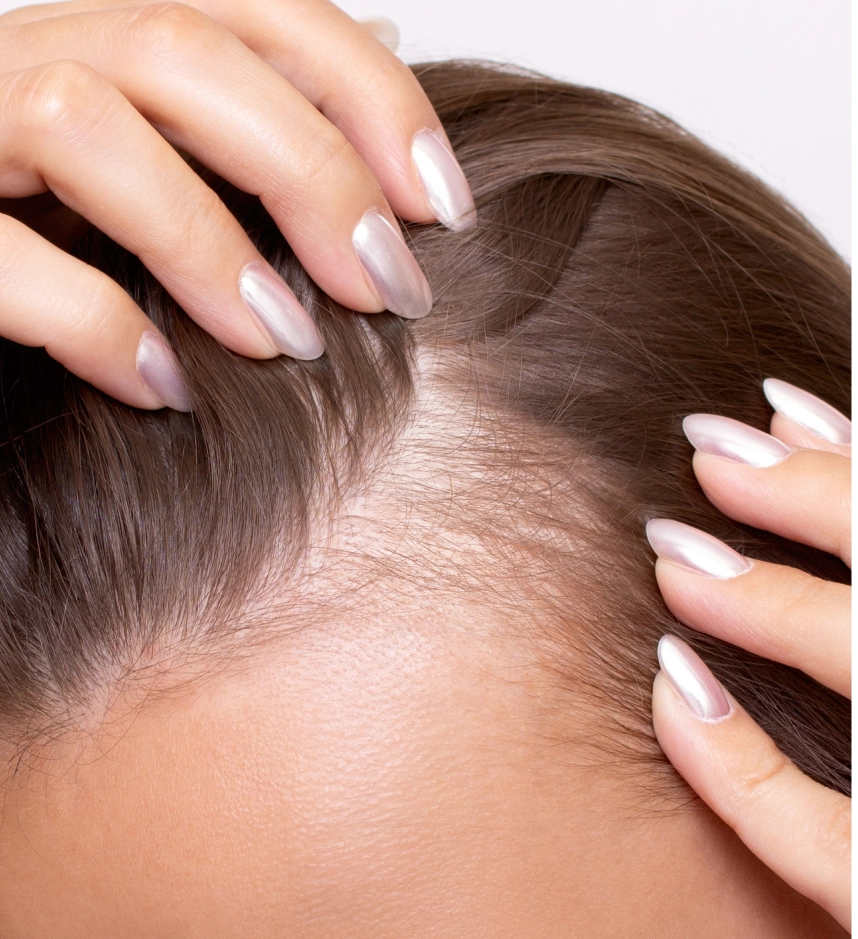 Hands with manicured nails touching scalp hair and skin