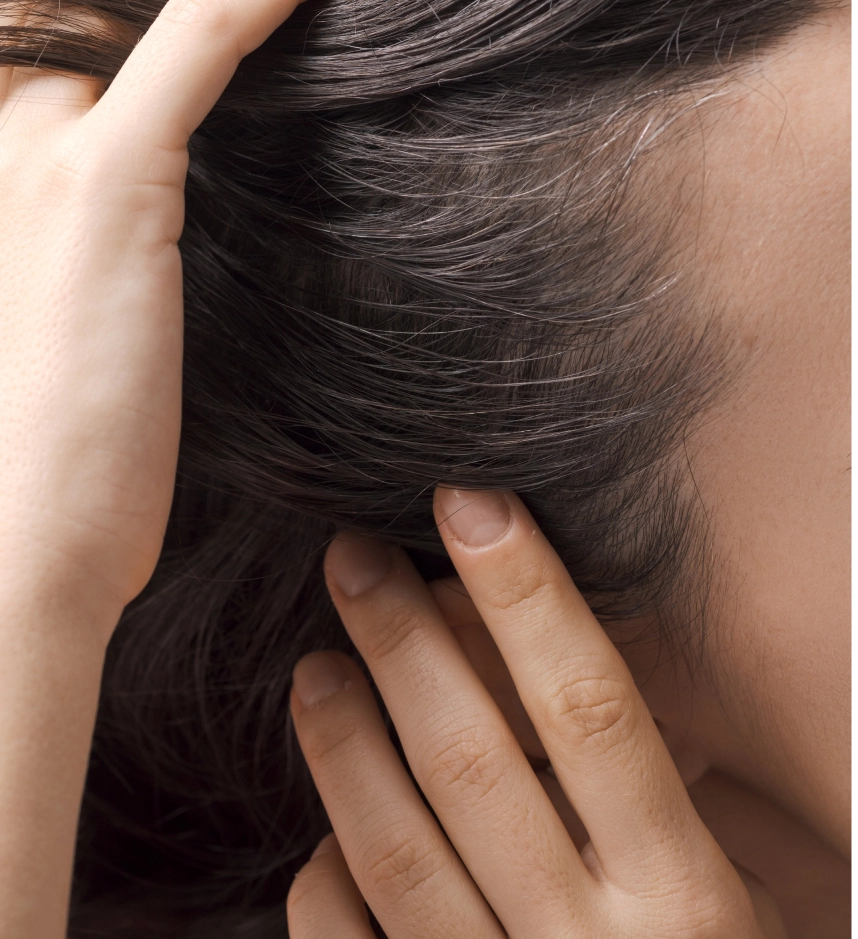 Person touching thick dark hair on scalp and neck