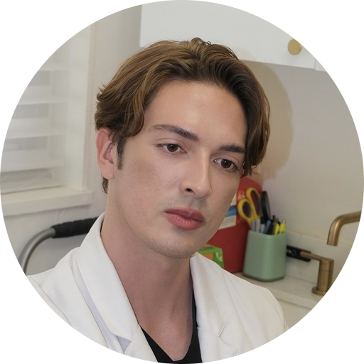Dermatologist Charles Jovaliano in white coat at clinic desk