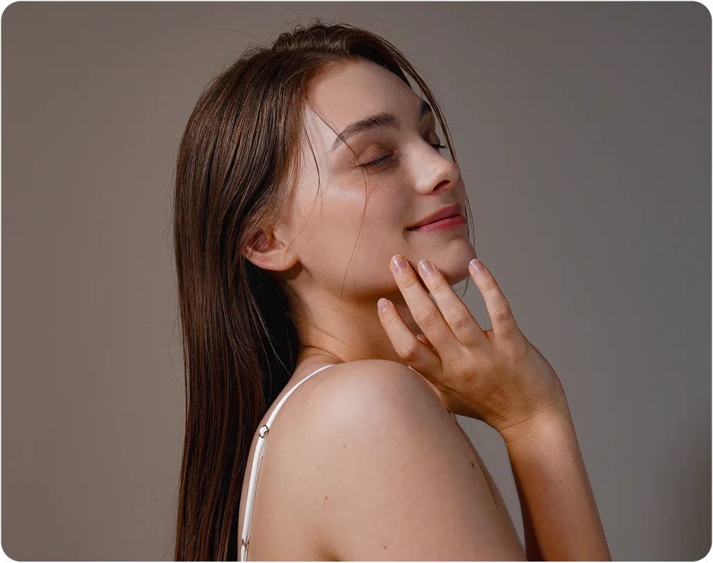 Woman with wet hair touching her chin and neck