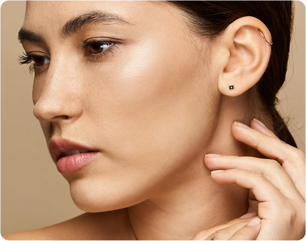 Woman's face in profile showing clear skin, with hand touching neck area