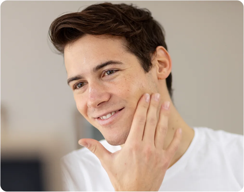 Man smiling while touching his cheek with his hand