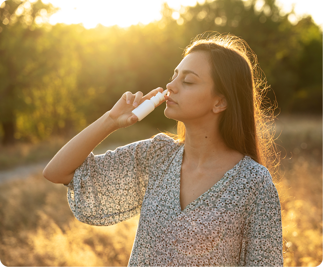 Woman using nasal spray outdoors in natural sunlight