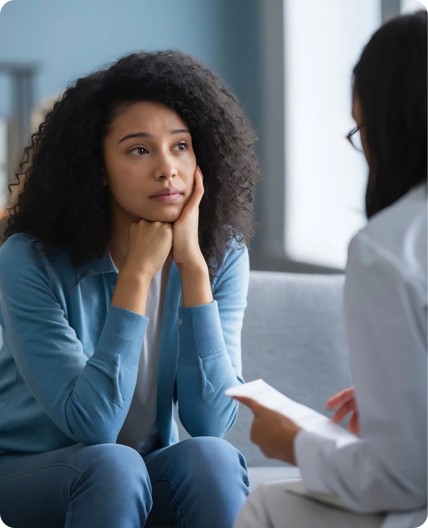 Woman in blue shirt listening thoughtfully during consultation with healthcare provider