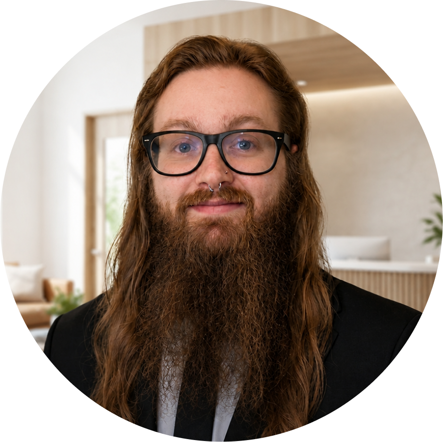 Man with long brown hair and beard wearing glasses, headshot in clinic setting