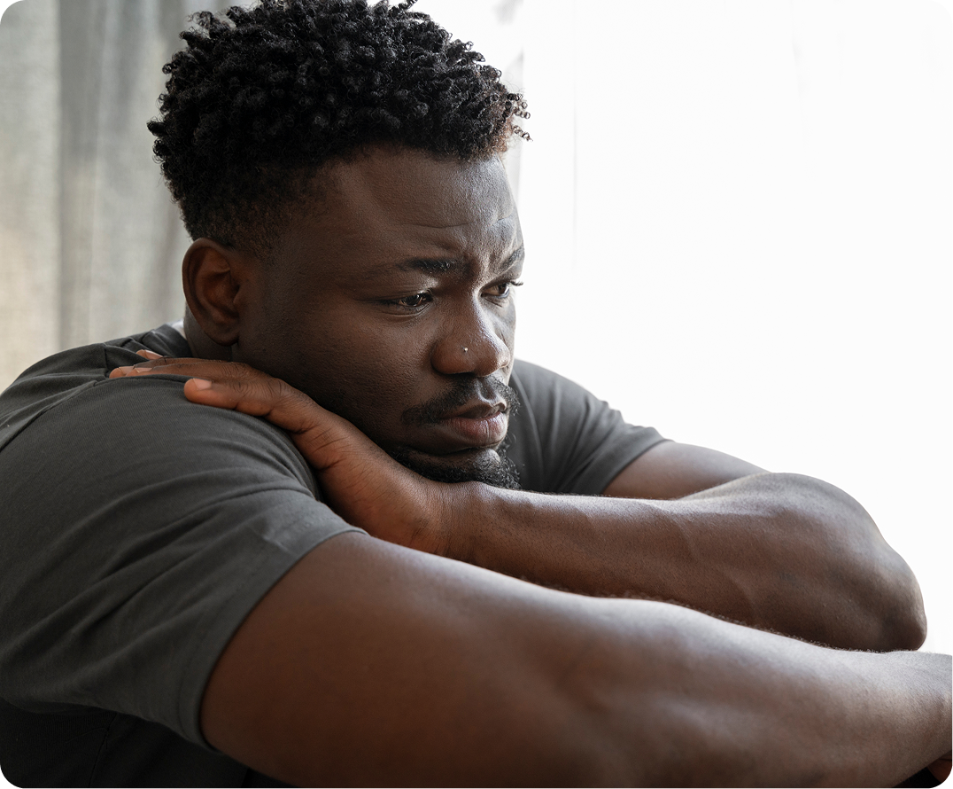 Man in dark shirt looking downward with concerned expression