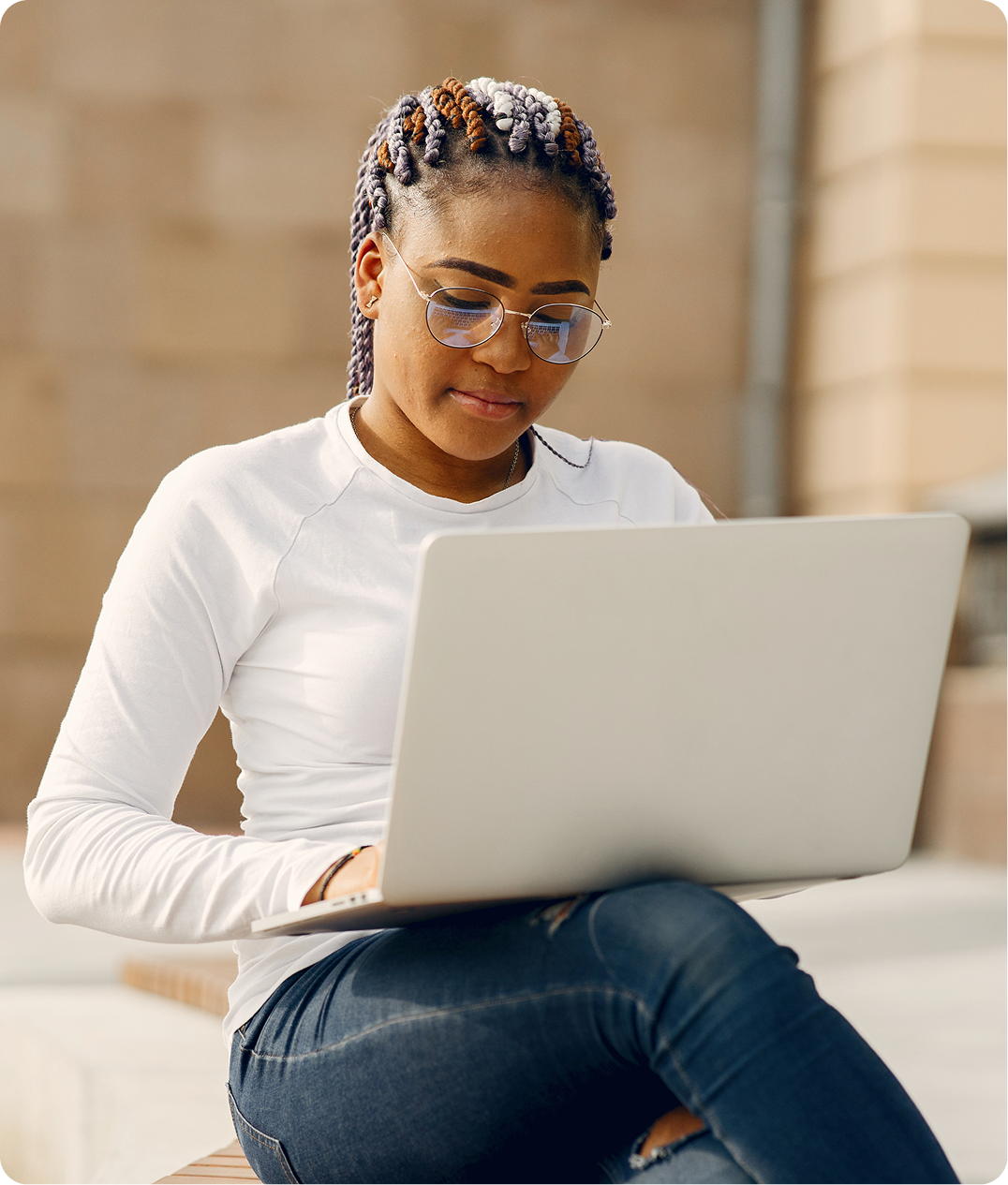 Woman wearing glasses working on laptop indoors