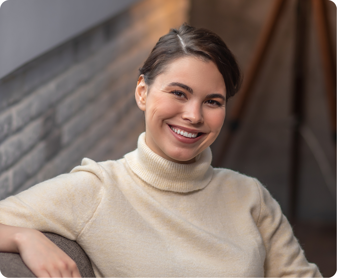 Woman smiling at camera wearing cream turtleneck sweater