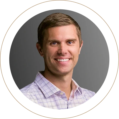 Man in lavender plaid shirt smiling, circular frame with tan border