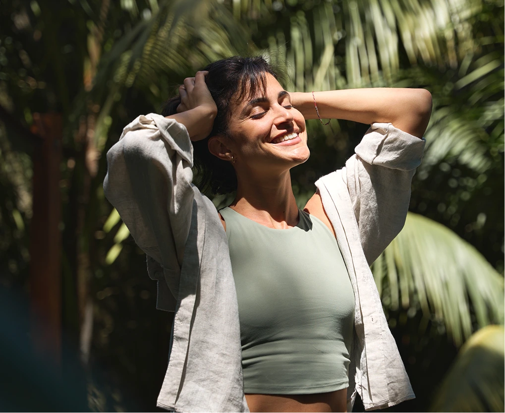 Woman smiling among palm leaves