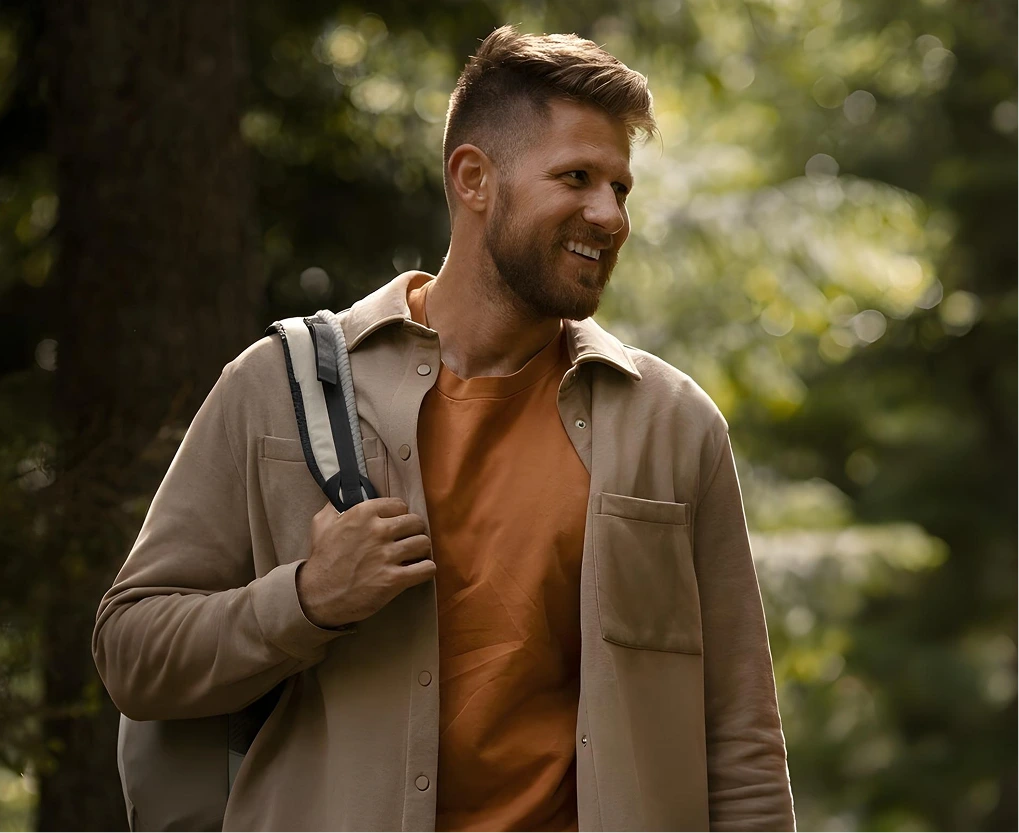 Smiling man with a backpack in the woods