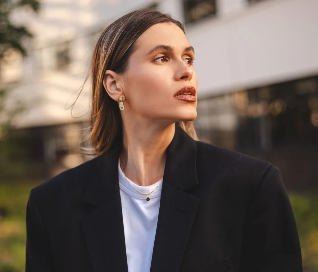 Woman in a black blazer outdoors