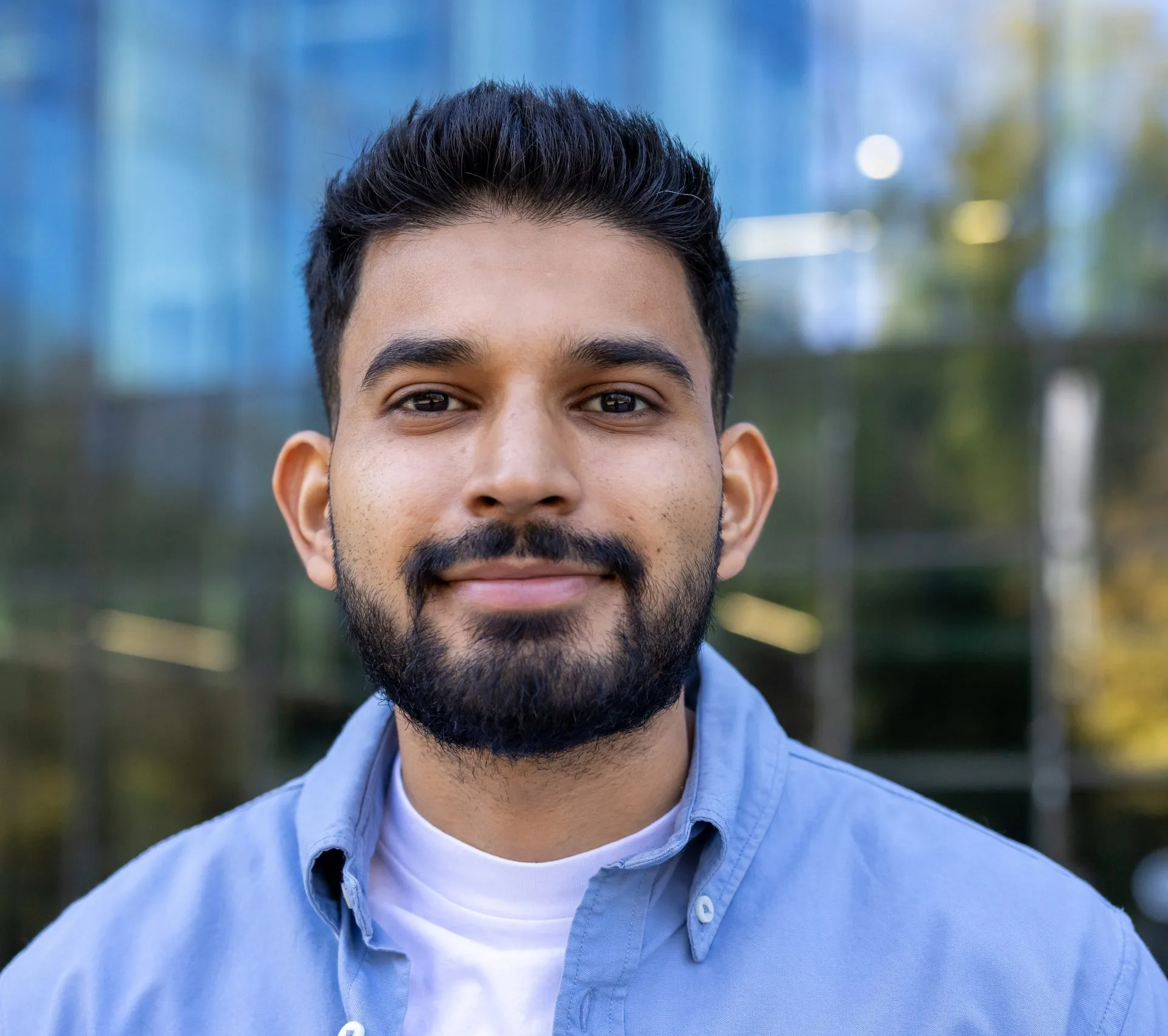 Bearded man in a blue shirt smiling