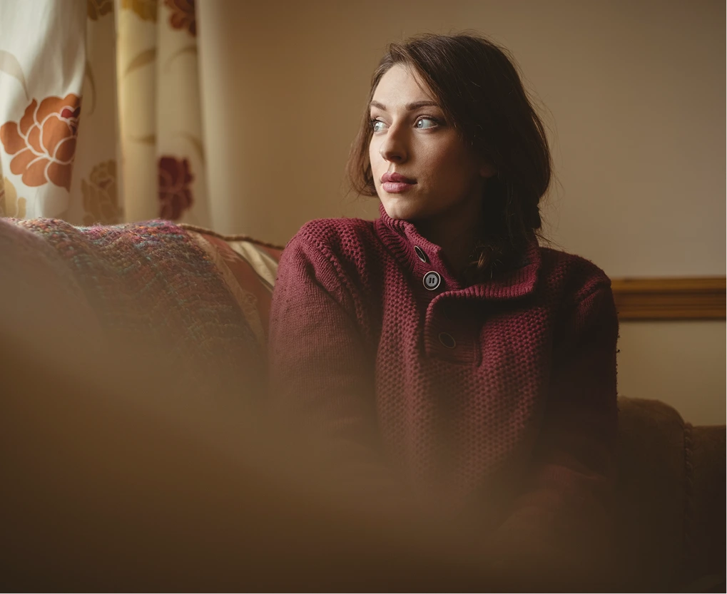 Woman looking out a window at home