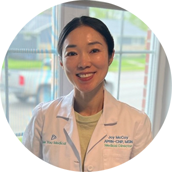 Female physician in white coat smiling at window
