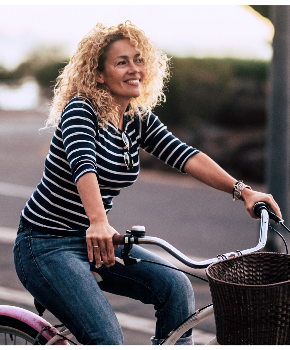 Smiling woman riding a bicycle outdoors