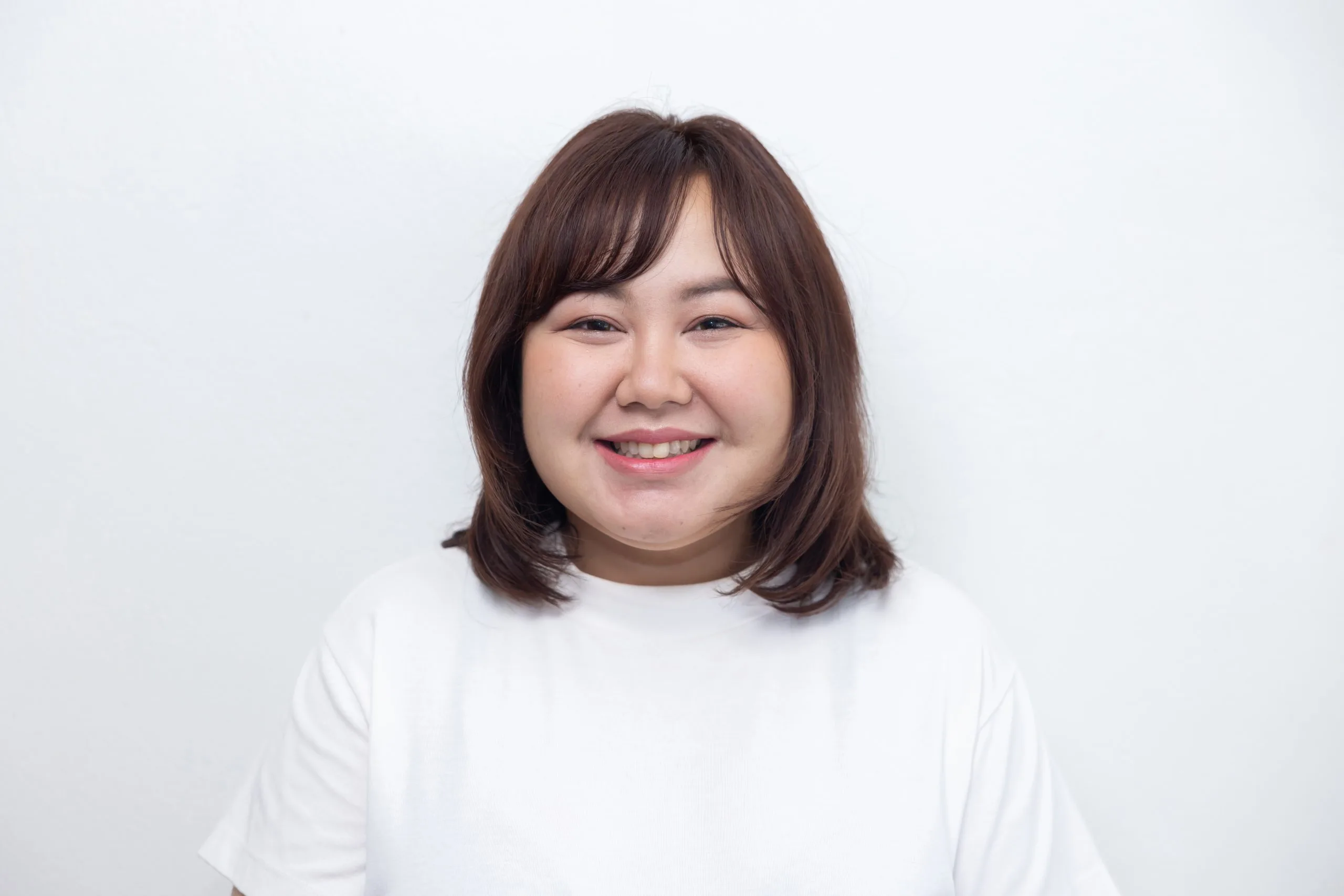Woman smiling at camera against white background