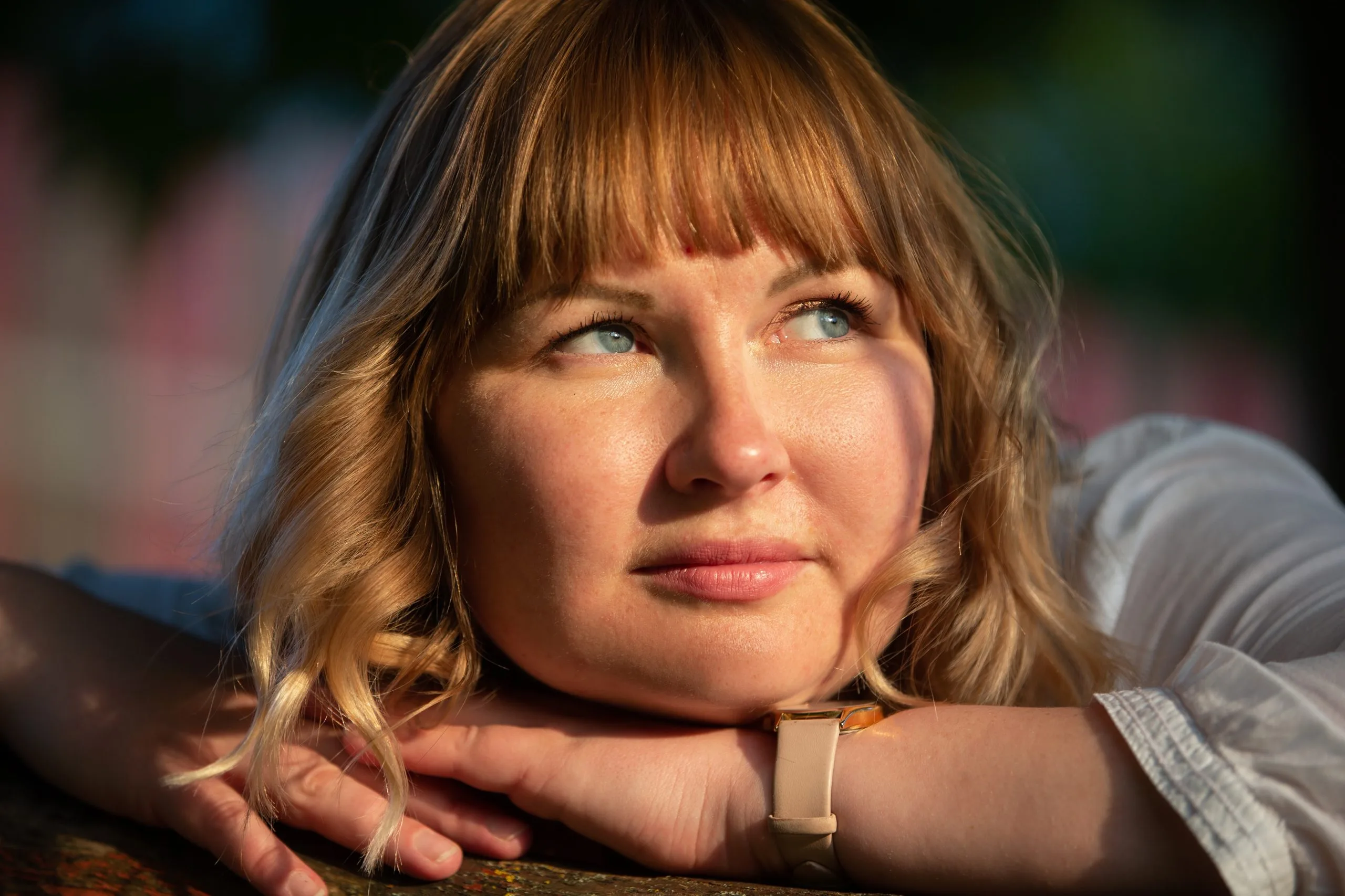 Woman with brown hair and blue eyes looking thoughtfully away