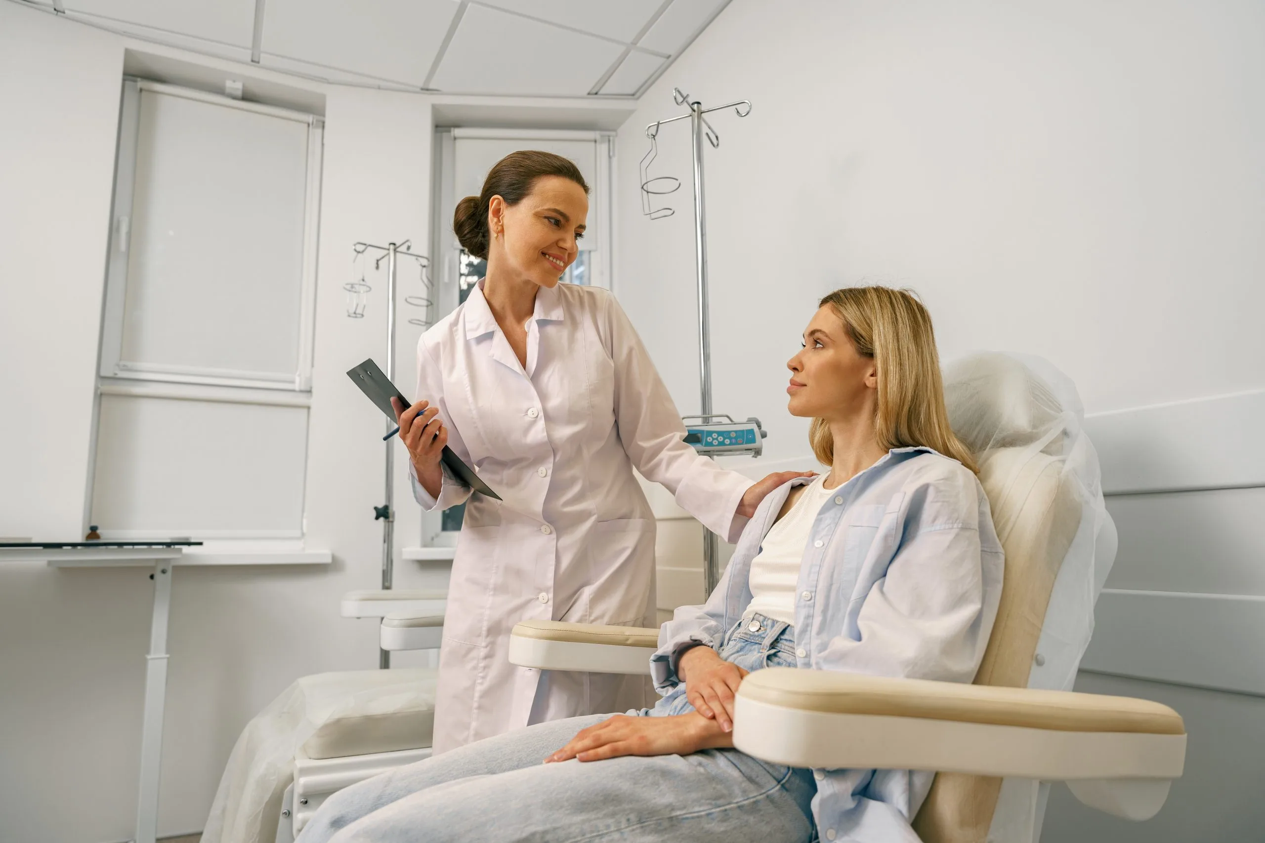 Healthcare provider discussing treatment plan with patient in clinical infusion therapy setting