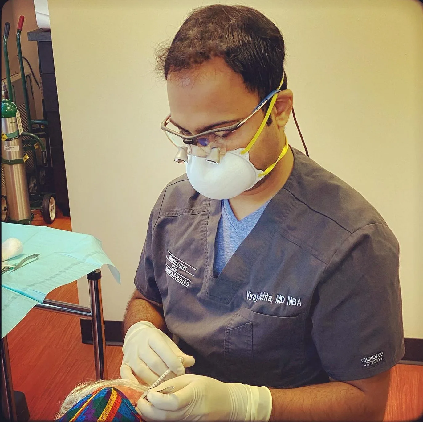 Surgeon wearing protective eyeglasses and mask examining colorful surgical training model on table