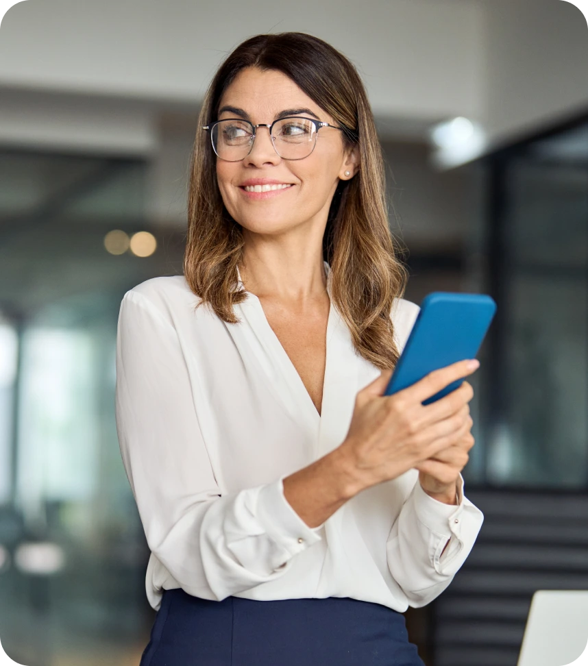 Woman wearing glasses holding blue smartphone in modern clinic setting