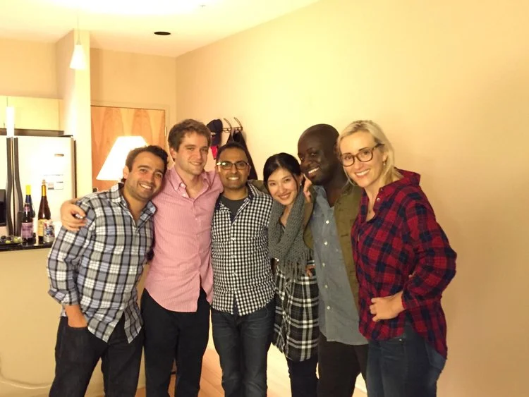 Six staff members smiling together in a medical office break room