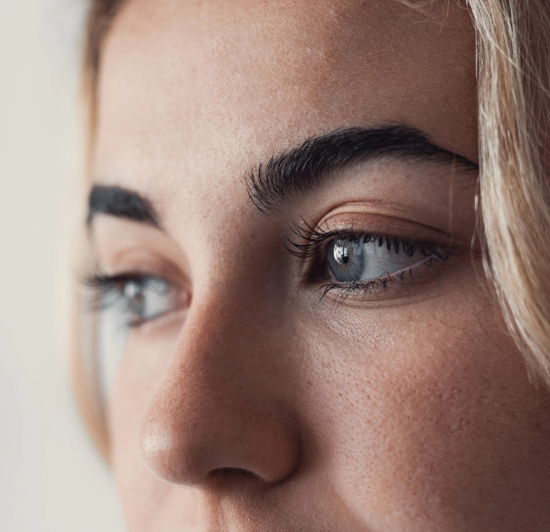 Side profile of woman's face highlighting blue eye and full lashes