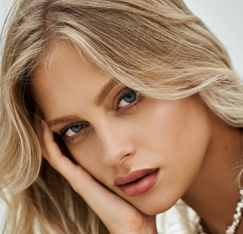 Woman with blonde hair and blue eyes looking downward