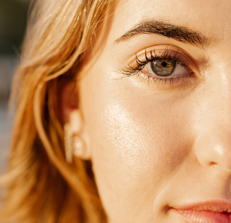 Woman's face in profile with reddish-blonde hair and brown eye