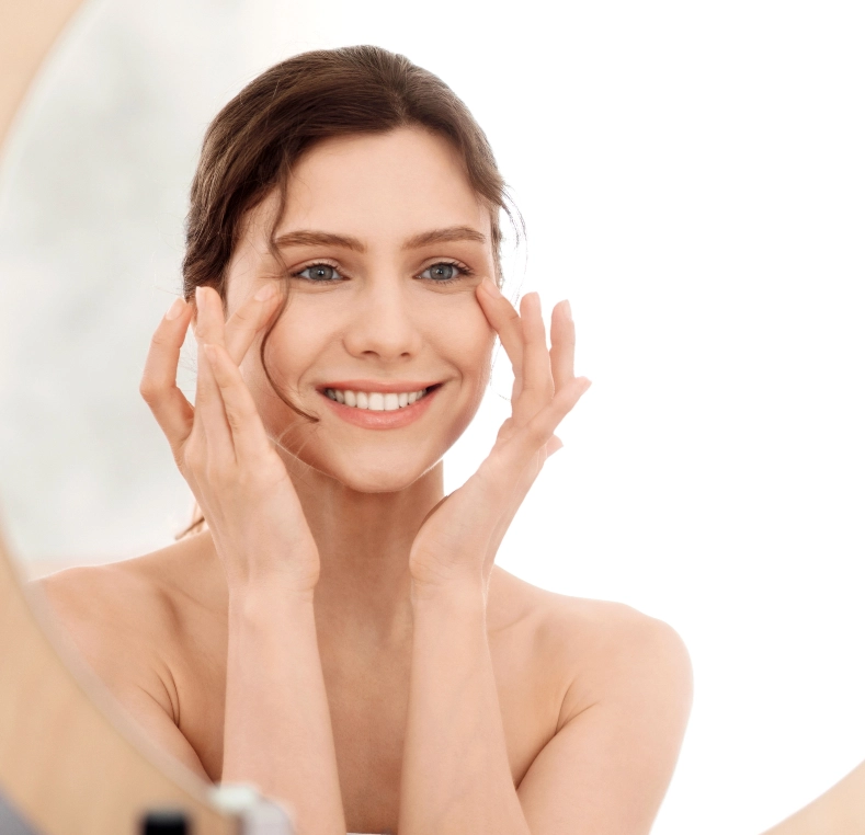 Woman smiling while touching her face with both hands