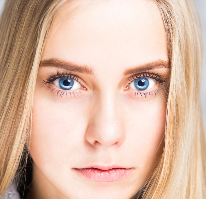 Woman's face looking directly at camera with blue eyes and blonde hair