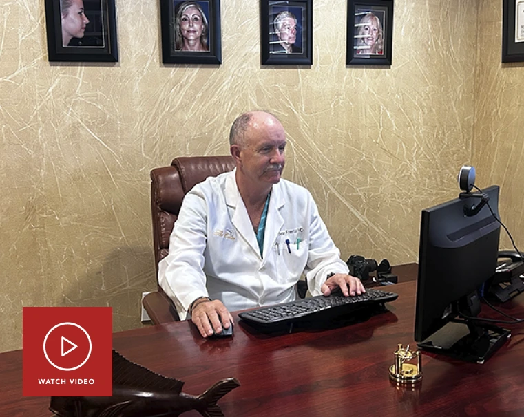 Physician in white coat at desk with computer and before-and-after portrait gallery on wall behind