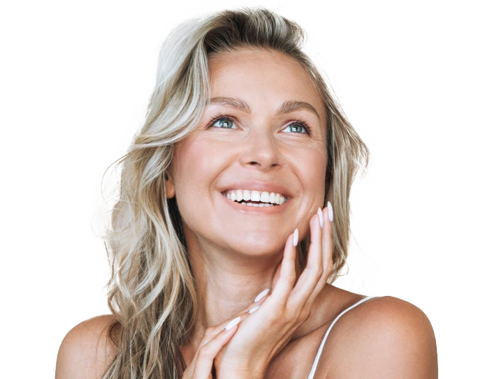 Woman with blonde wavy hair smiling while touching her face
