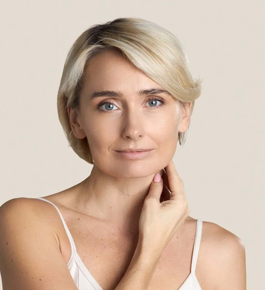 Mature woman touching her neck and jawline, the areas a triplanar facelift treats