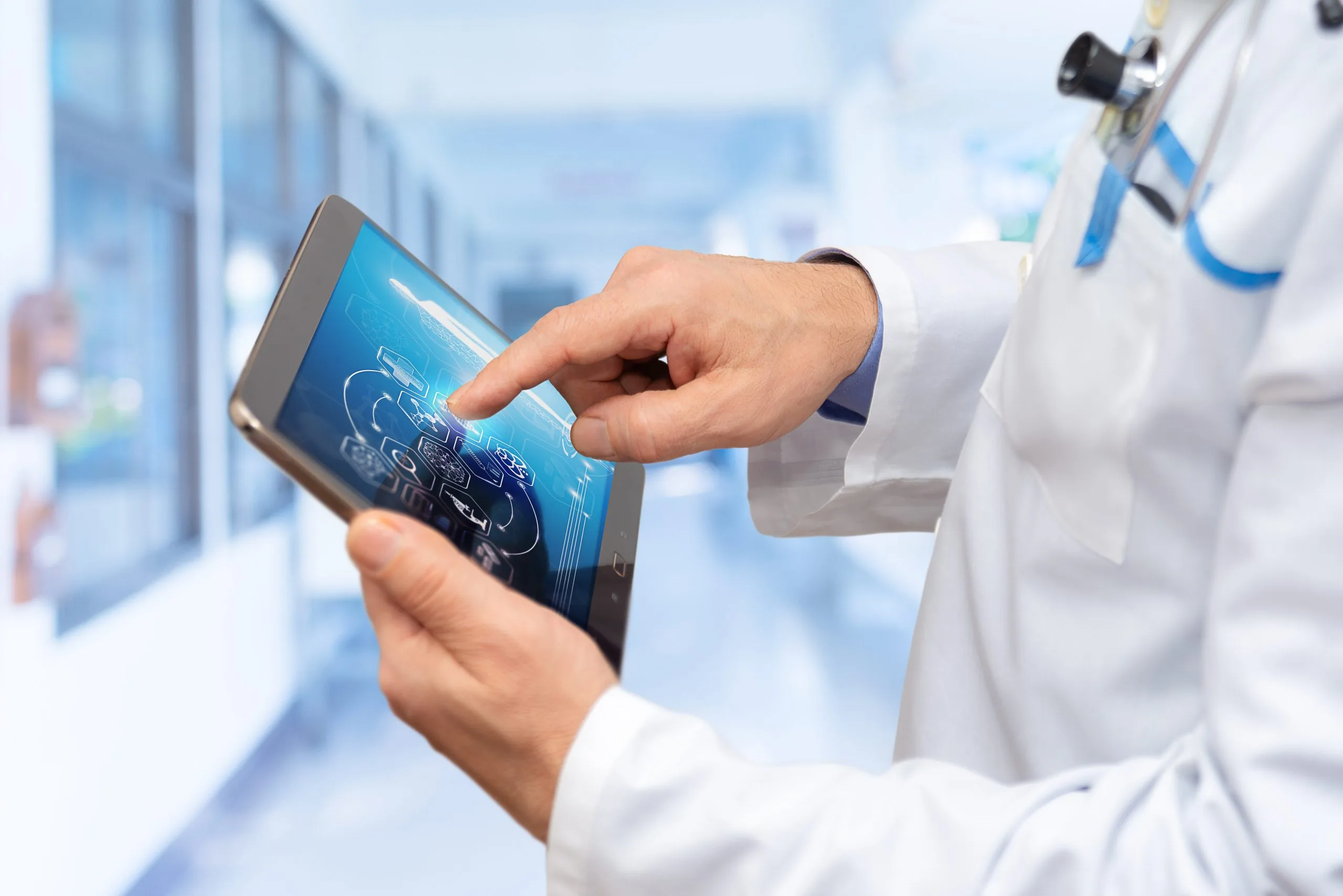 Healthcare professional in white coat viewing digital medical data on tablet in modern clinical setting