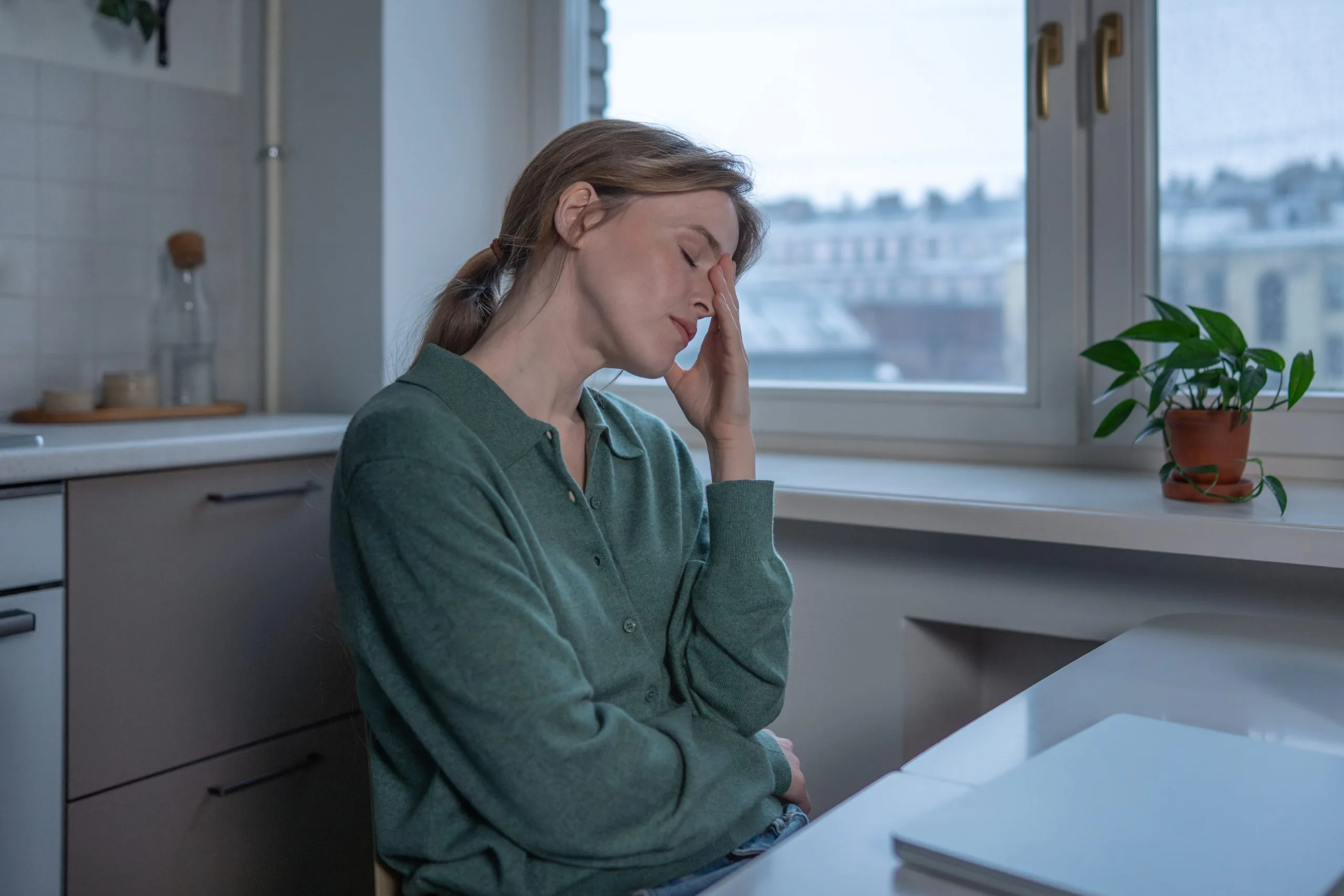 Tired woman resting her head in her hand at home