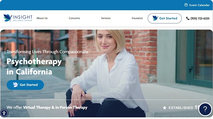 Smiling blonde woman in white shirt leaning against brick wall, Insight Wellness Center offering virtual and in-person psychotherapy in California