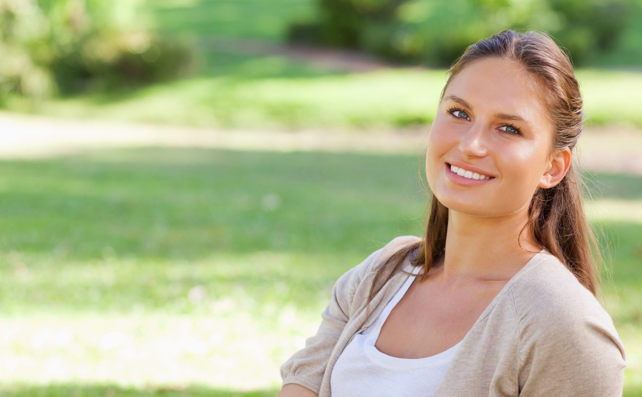 Woman smiling at camera in outdoor park setting