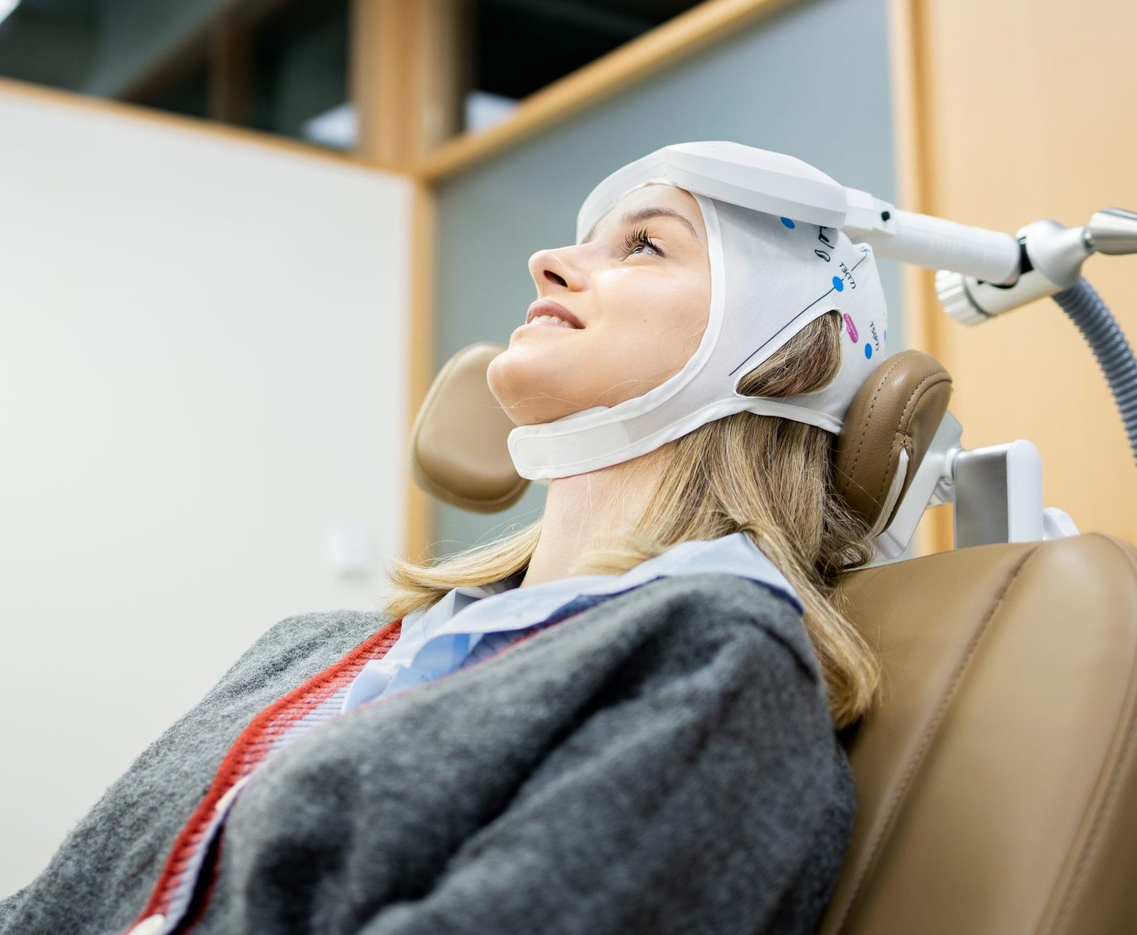 Patient receiving facial treatment with white therapeutic device in clinical setting