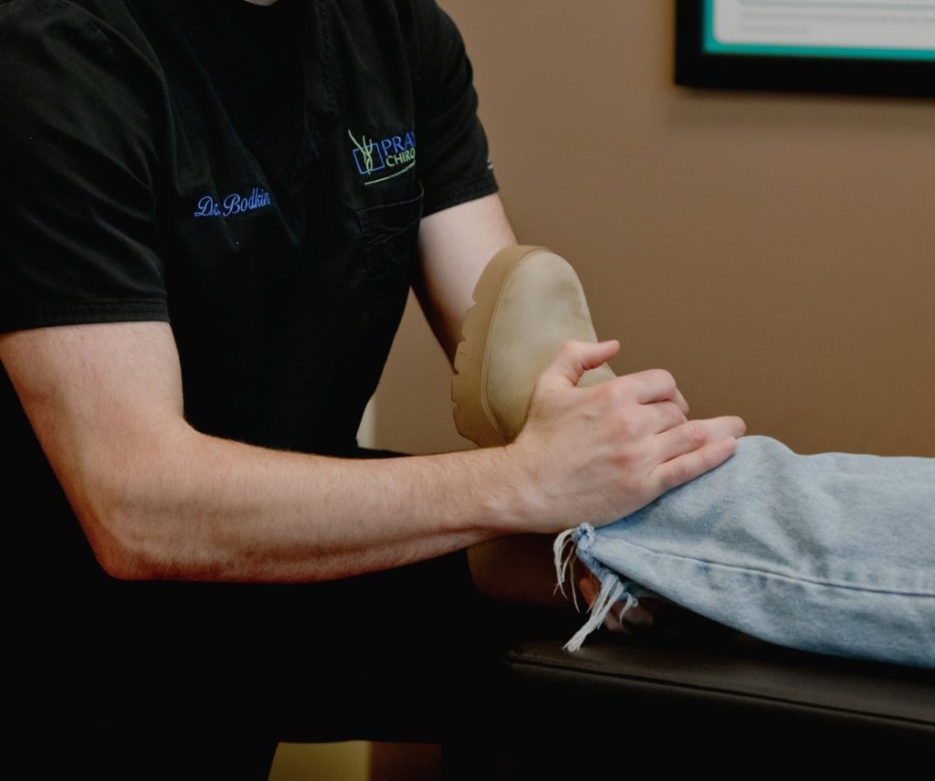 Chiropractor performing soft tissue massage on patient's leg