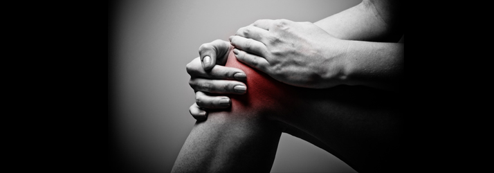 Person holding knee with red highlight indicating joint inflammation